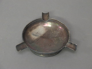 A circular silver ashtray
