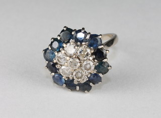 An 18ct white gold or platinum cluster dress ring set numerous diamonds supported by sapphires