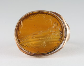 An oval gold ring set an intaglio cut seal in the form of a naked  lady