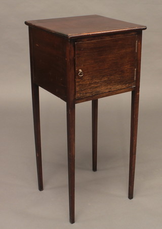 A mahogany bedside cabinet enclosed by a panelled door raised  on square tapering supports 15"