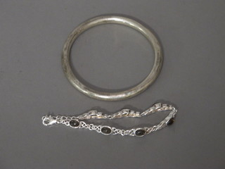 A silver bangle and a pierced white metal bracelet