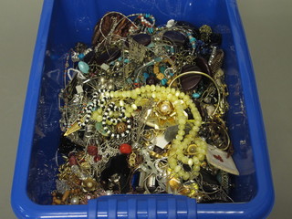 A blue crate containing a collection of costume jewellery
