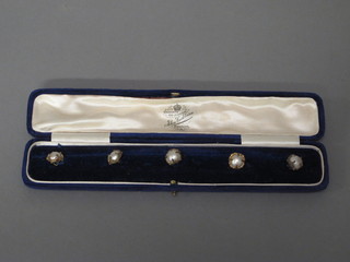 A set of 5 gilt metal and pearl finished buttons, cased