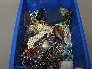 A blue crate containing a collection of costume jewellery