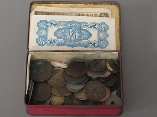 A tin box containing a small collection of coins