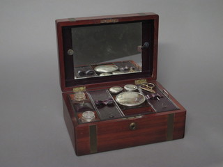 A Victorian mahogany vanity box with hinged lid fitted a mirror, the interior containing 3 cut glass bottles with silver plated lids, 2  cut glass bottles and a pair of scissors