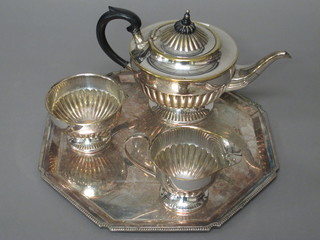 A circular 3 piece silver plated tea service with demi-reeded decoration comprising teapot, sugar bowl and milk jug together  with a silver plated tray with bracketed border