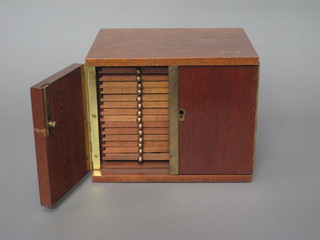 A teak coin collector's cabinet, the interior fitted 14 drawers enclosed by panelled doors 9 1/2"