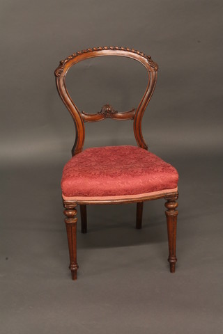 A Victorian mahogany balloon back dining chair with shaped mid rail, raised on turned and fluted supports