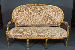 A carved and gilt painted French style 5 piece salon suite comprising open arm sofa and 4 armchairs with upholstered seats  and backs, raised on turned and reeded supports