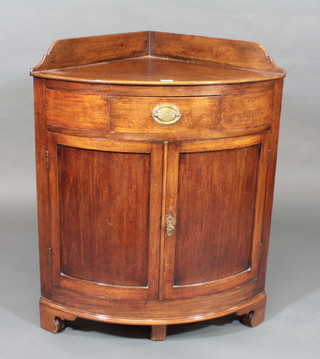 A 19th Century mahogany bow front corner cabinet with raised  back, fitted a drawer above a cupboard enclosed by panelled  doors, raised on bracket feet 30"