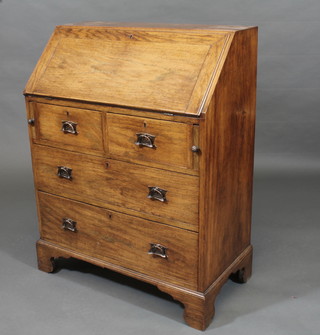 An Art Nouveau oak bureau with fall front revealing a well fitted interior above 2 short and 2 long drawers with brass drop  handles, raised on bracket feet 30"