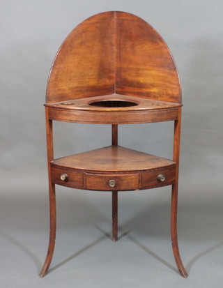 A Georgian mahogany corner washstand with raised back, the top fitted 3 bowl recepticals, the base fitted 1 long drawer, raised  outswept supports 26"