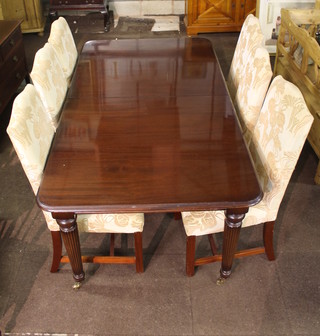 A dining room suite comprising a mahogany extending dining  table raised on turned and reeded supports together with 6 high  back dining chairs