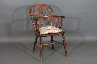 A yew and elm Windsor chair with H framed stretcher, raised on turned supports