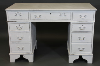 A white painted kneehole pedestal desk fitted 1 long and 8 short drawers, raised on bracket feet 48"