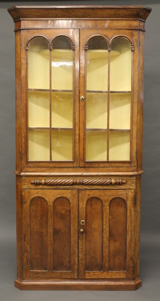 A Georgian Country oak double corner cabinet, the upper section  with moulded cornice, fitted shelves enclosed by arch glazed  panelled doors, base fitted a double cupboard 87"   ILLUSTRATED