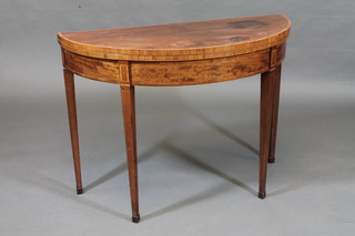 A Georgian mahogany demi-lune card table with crossbanded  top, raised on square tapering supports 38"   ILLUSTRATED