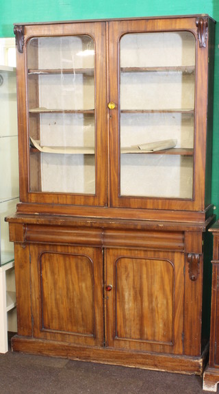 A Victorian mahogany bookcase on cabinet the upper section  fitted adjustable shelves enclosed by glazed panelled doors, the  base fitted 2 long drawers above a double cupboard 47"