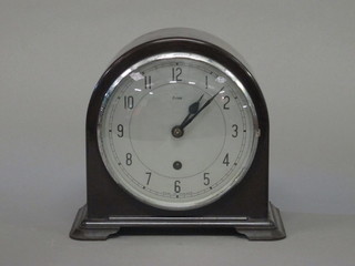 A 1950's mantel clock with silvered dial and Arabic numerals contained in an arch shaped Bakelite case