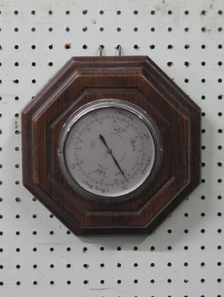 An aneroid barometer with silvered dial marked SB, contained in an oak octagonal case 8 1/2"