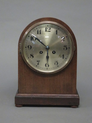An Edwardian 8 day striking mantel clock with silvered dial and Arabic numerals contained in an arch shaped mahogany case
