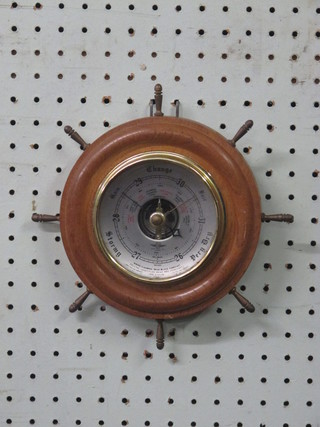 An aneroid barometer with silvered dial by SB contained in a  turned oak ships wheel case 7"