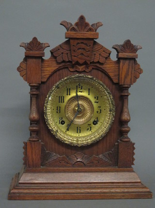 An American 19th Century 8 day striking mantel clock with gilt  dial and Arabic numerals, contained in an oak case