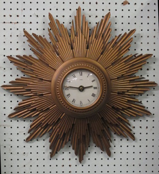 A battery operated sunburst wall clock contained in a carved gilt  case