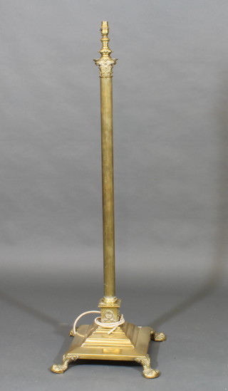 An adjustable brass reeded standard lamp with Corinthian capital raised on a square stepped base