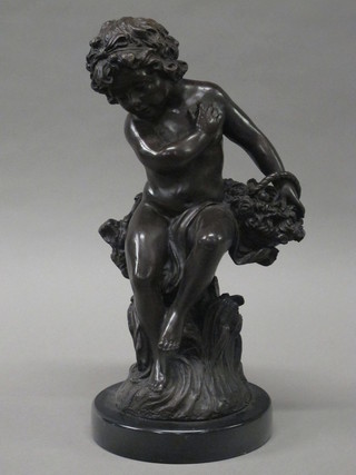 A bronze figure of a seated cherub with basket, raised on a circular marble base 14"
