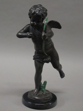 A bronze figure of a cherub with bow, raised on a marble base  14"