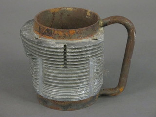 A metal mug fashioned from a cylinder from a Porsche motor car