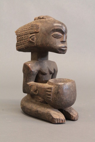 A carved wooden African figure of a kneeling lady 13"