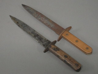 A double bladed fighting dagger with 8" blade and copper grip  and 1 other dagger with 8" blade