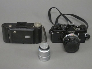 An Olympus OM2 camera, a Baldafix folding camera and a Bell  & Howel-Angenieux 10mm lens