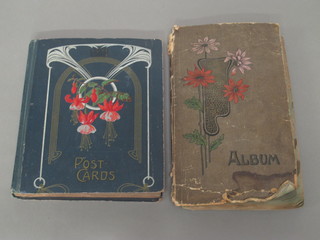 A green album of various coloured postcards together with a  blue album of postcards, cover decorated fuscia