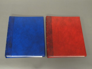 A red ring bind album and a blue ring bind album of postcards, mostly buses