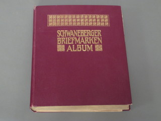 A Schwaneberger red stamp album containing a collection of  World stamps