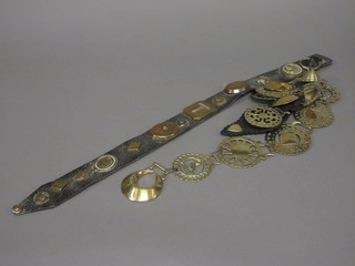 A leather martingale hung horse brasses and a collection of horse brasses