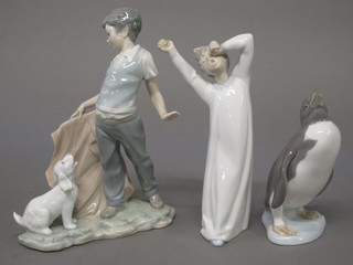 A Lladro figure of a standing penguin, base marked 1984 6", do. figure of a standing yawning boy 8" and a Nao figure of a  standing boy with dog 10"