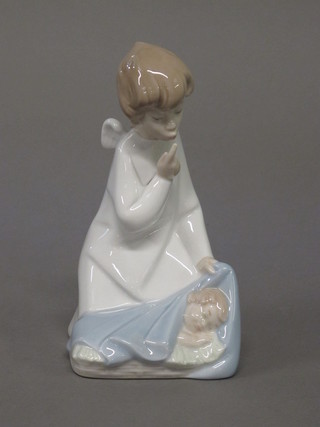 A Lladro figure of a kneeling Angel with baby 7"