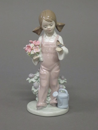 A Lladro figure of a girl with bird and watering can 7"