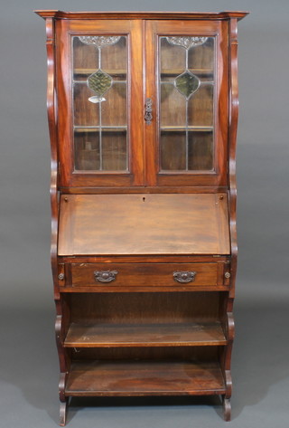 An Art Nouveau mahogany bureau bookcase, the upper section  fitted shelves enclosed by lead glazed panelled doors, the base  fitted a fall front above 1 long drawer, the base fitted a shelf 32"