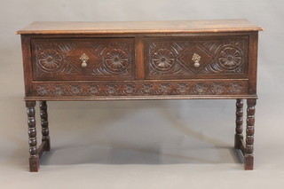 A carved oak dresser base fitted 2 long drawers, raised on ring turned supports 53"