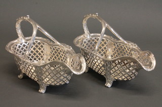 A pair of large pierced silver plated wine bottle cradles, raised on panelled supports 10"