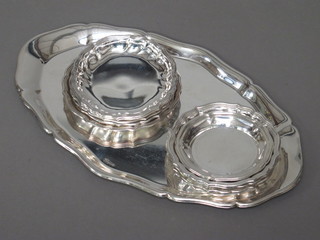 An oval white metal dish with bracketed border 10" together with  10 circular Danish white metal dishes with bracketed borders