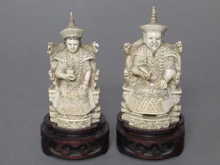 A pair of carved ivory figures of seated Deities 4 1/2", the base with seal mark