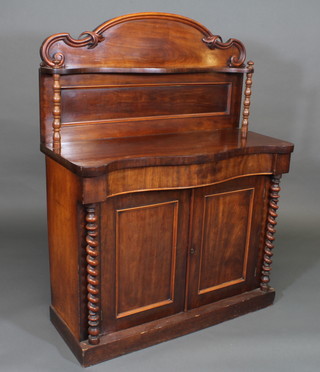 A Victorian mahogany chiffonier of serpentine outline with raised back, the base fitted 1 long drawer above a double cupboard and  with spiral turned columns to the side 42"