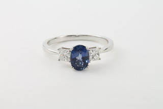 An 18ct white gold dress ring set an oval cut sapphire supported  by diamonds